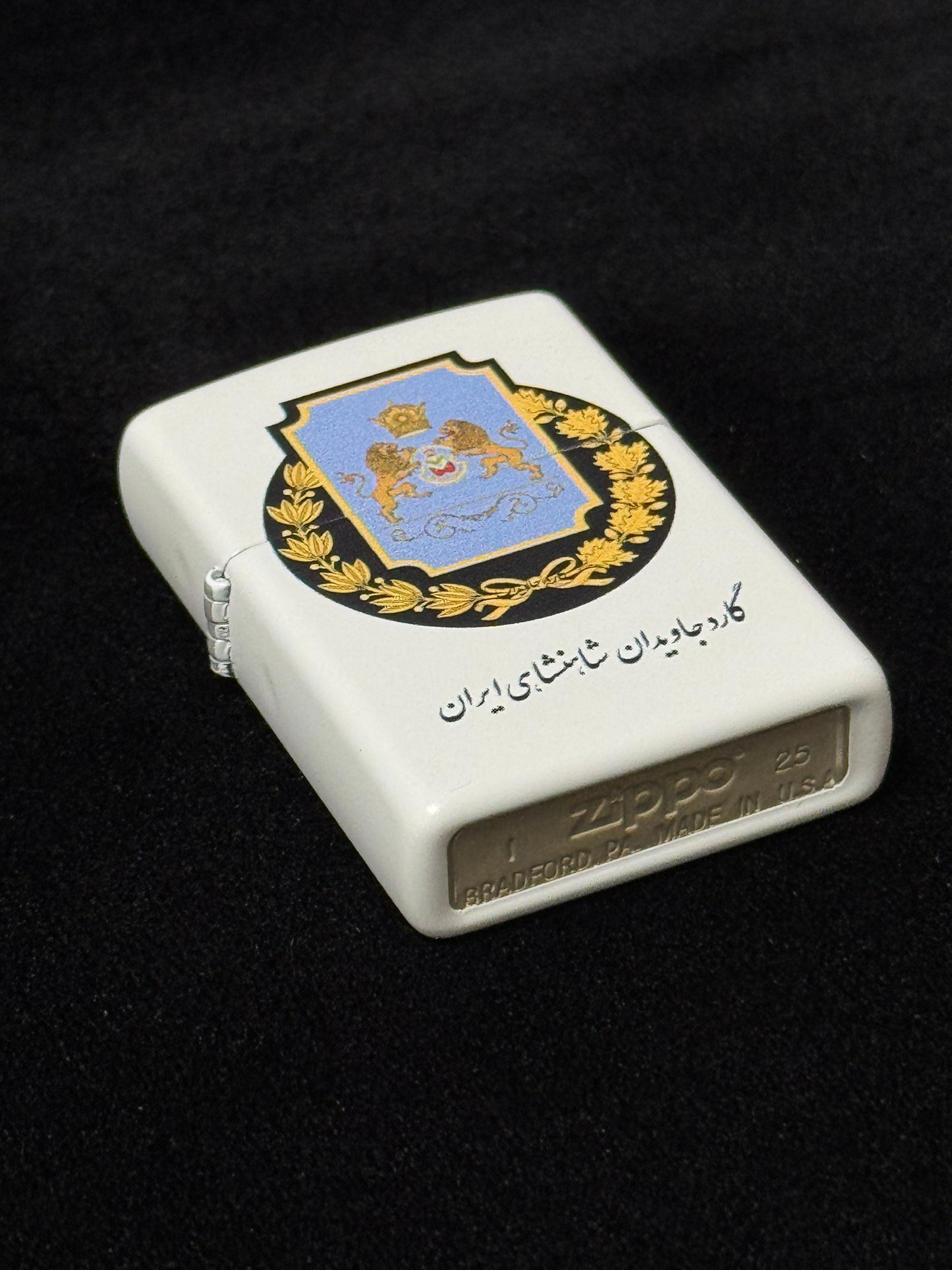White lighter with Imperial Javidan Guard of Iran emblem, crown, and two guardian lions on black background